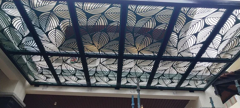 Decorative laser-cut steel canopy with patterned roofing panels by MD Fabrication